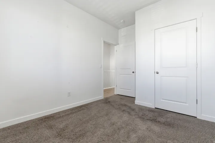 Neutral tone carpeting with white baseboards