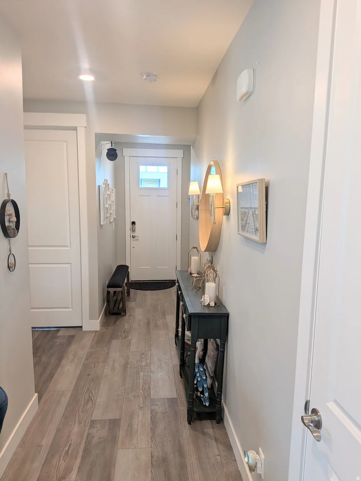 Inviting entry hallway featuring wood-finish flooring, recessed lighting, and a front door with integrated window panels