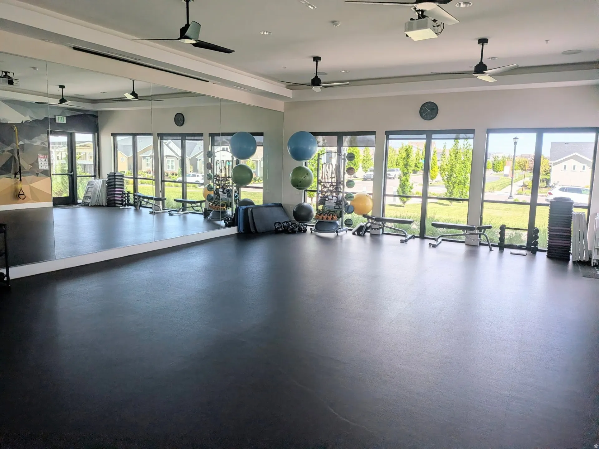 Spacious fitness studio featuring a durable rubberized floor and a wall of mirrors