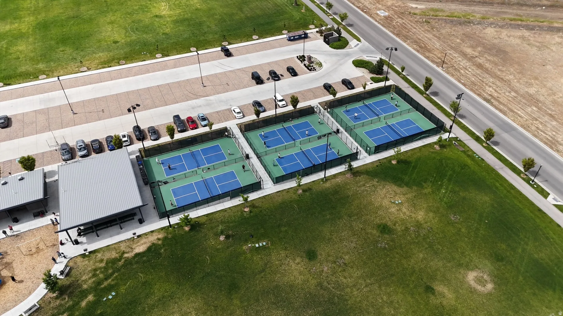 Three blue and green pickleball courts with perimeter fencing