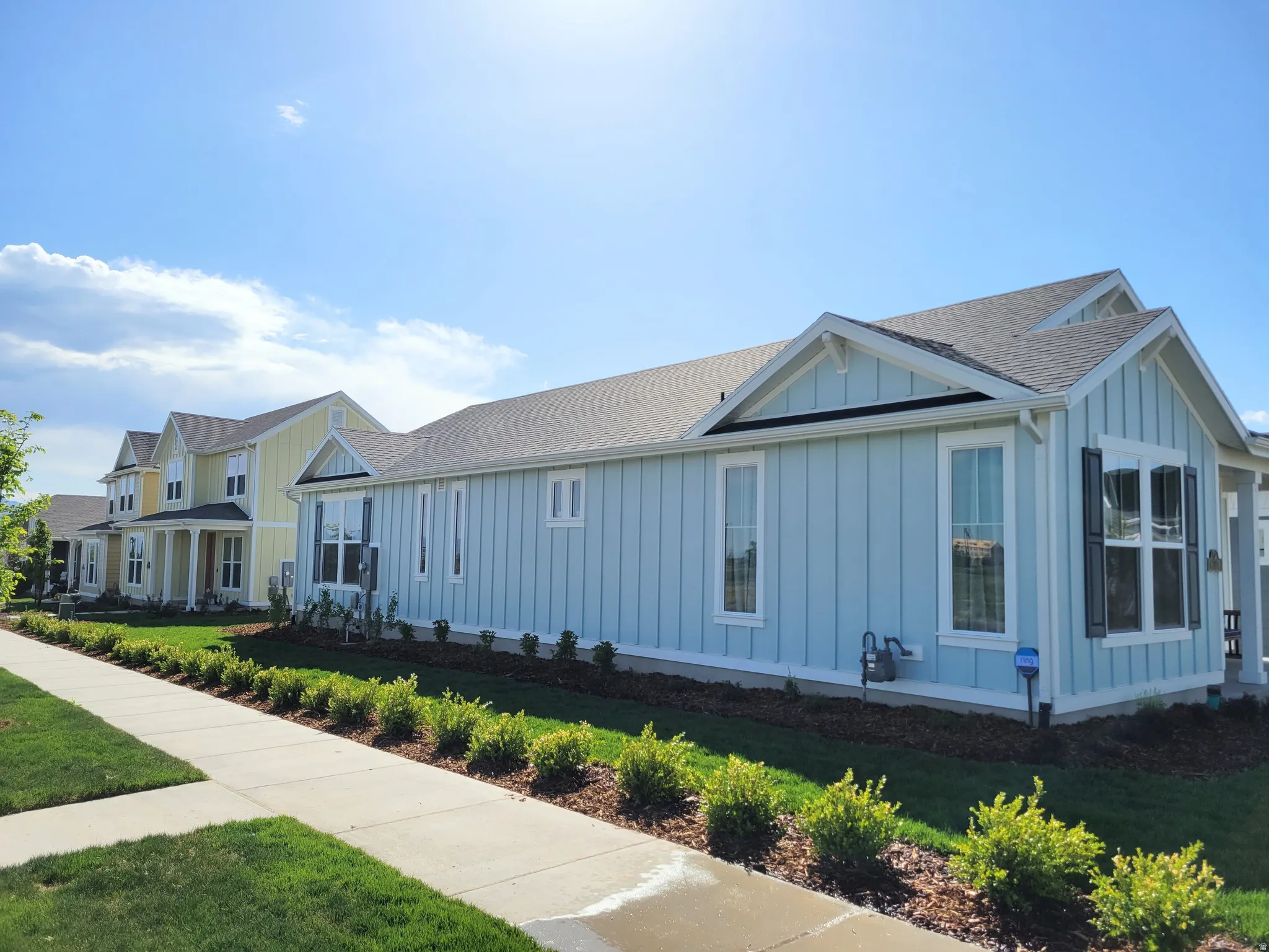 Light blue siding exterior with white trim, dark shutters, and a gray shingled roof