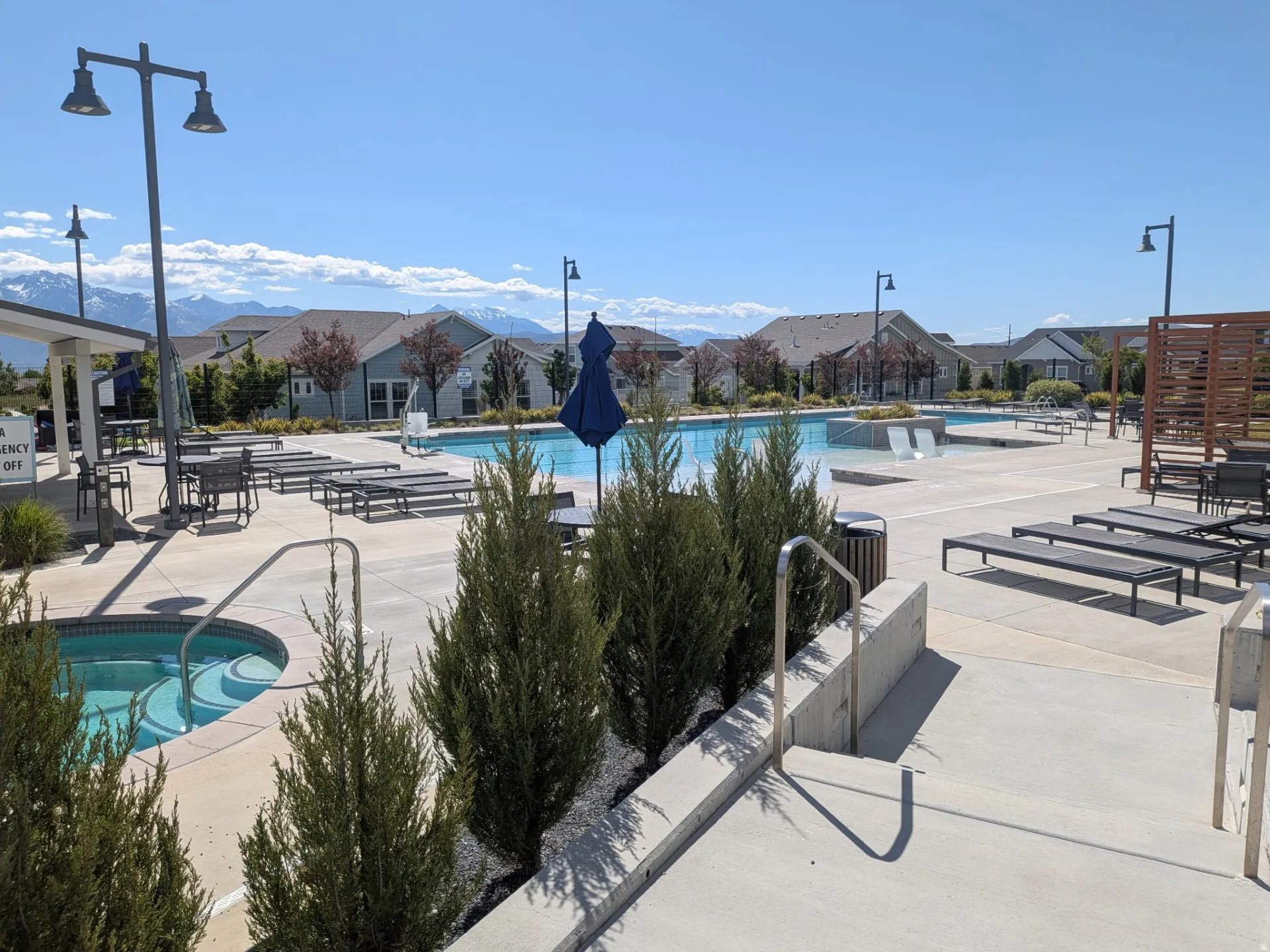 Community swimming pool with an integrated hot tub and ample lounge seating