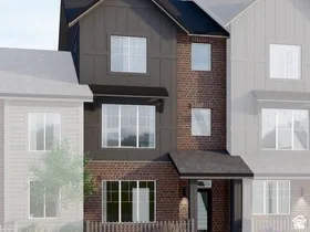 Modern townhome exterior featuring a dark board and batten facade and brick accents