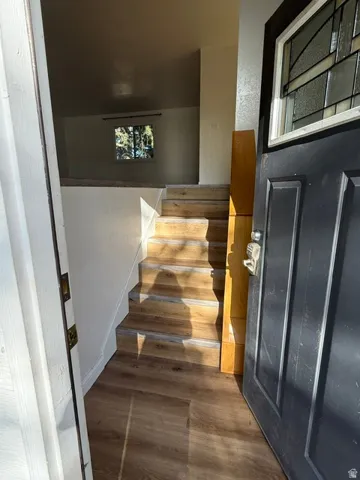 Wood-finish flooring throughout, with a split-level design featuring a staircase with matching wood-finish treads