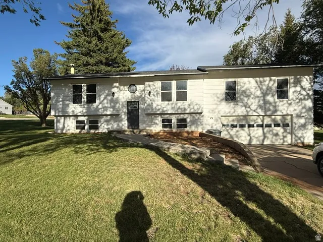 White siding exterior with a two-car garage, multiple windows, and a front entry