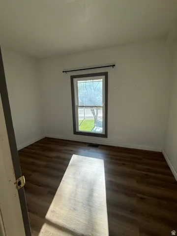 Wood-finish flooring with white baseboards and neutral wall tones