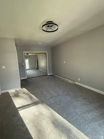 MASTER BEDROOM-Gray-toned walls with contrasting white trim, gray carpeting, and a modern ceiling fan with integrated lighting