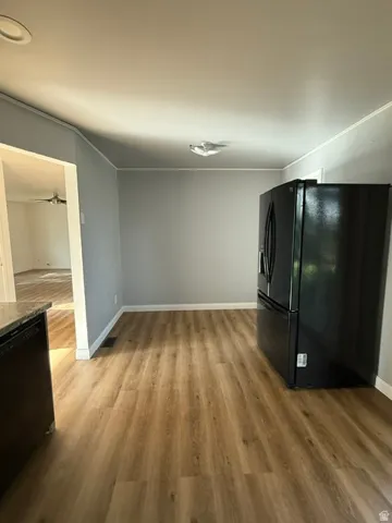 Wood-finish flooring with a black refrigerator
