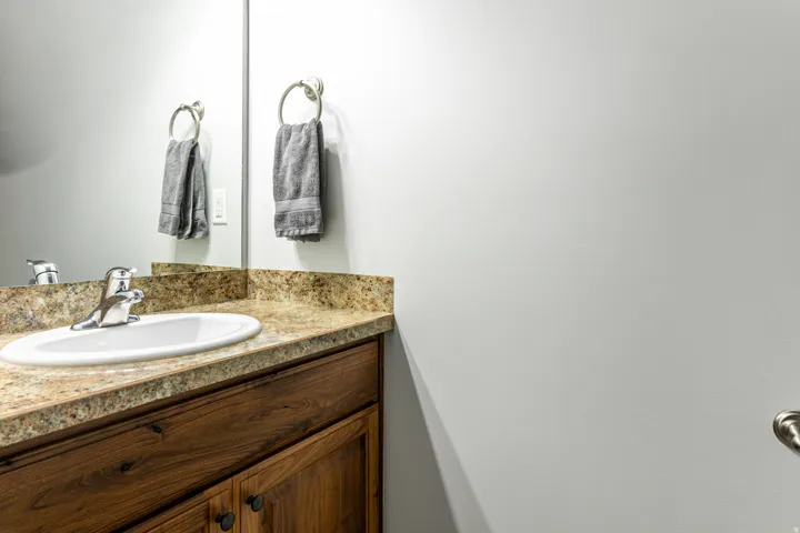 Bathroom vanity featuring a polished chrome faucet, an oval undermount sink, and a light-toned countertop