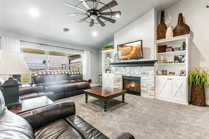 Living area with a stone-clad fireplace and built-in shelving