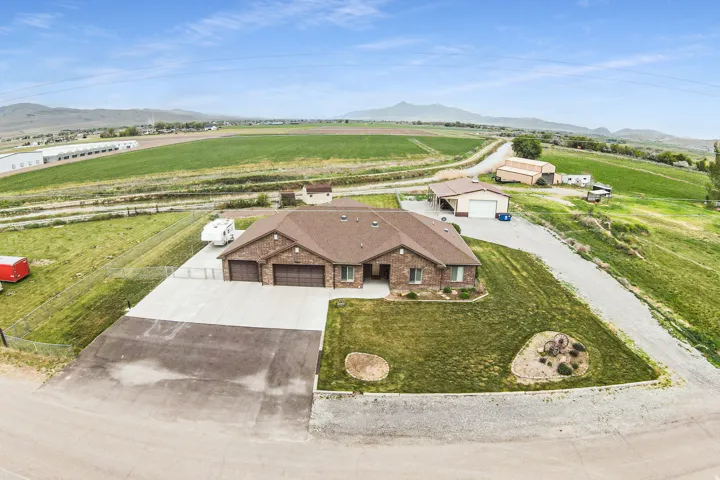 Brick single-story residence featuring a three-car garage, concrete driveway, and a landscaped front yard