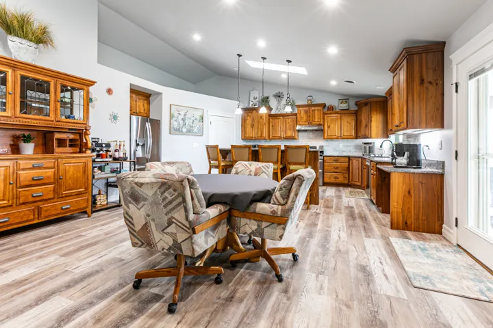 Spacious kitchen featuring wood cabinetry, stone-finish countertops, and stainless steel appliances