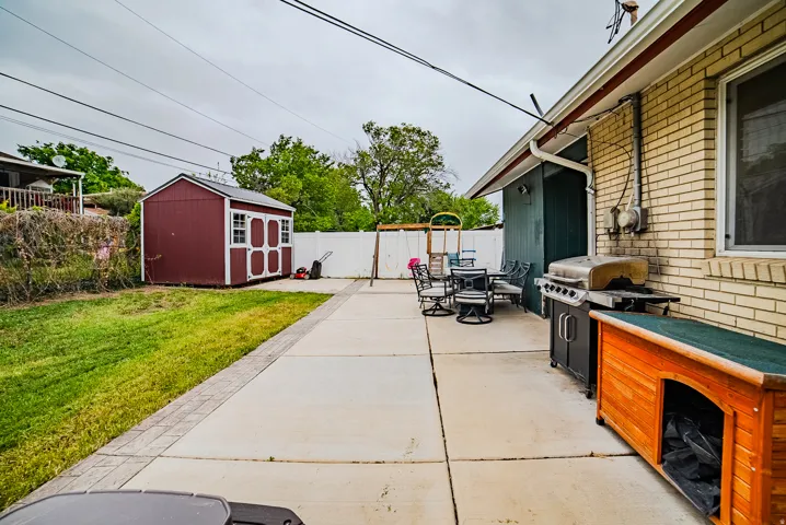 Expansive concrete patio area with brick exterior and white gutter system