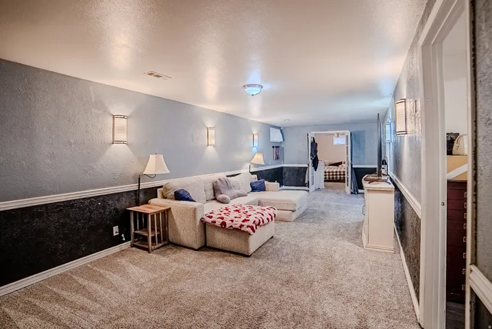 Spacious recreation room featuring textured walls, wainscoting, and recessed lighting