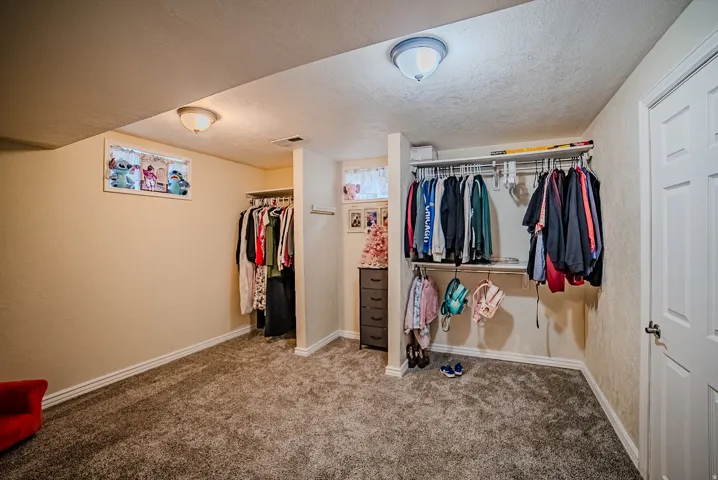Spacious room featuring plush gray carpeting and neutral wall paint
