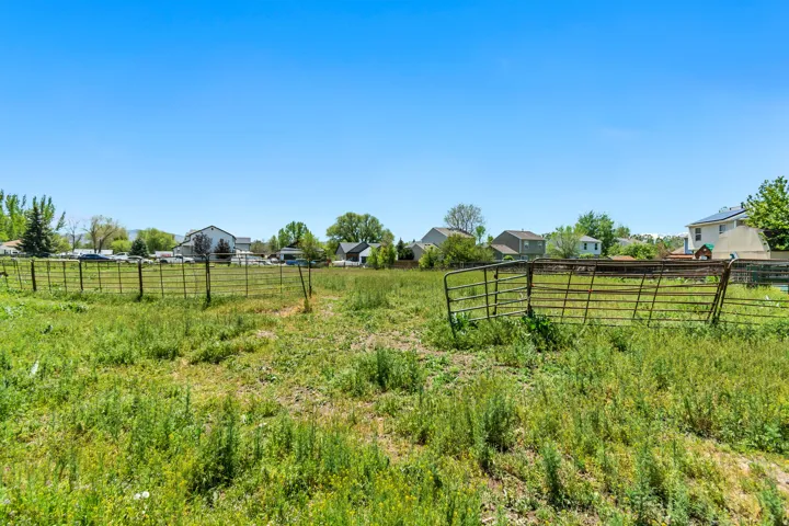 Expansive grassy lot with existing metal fencing