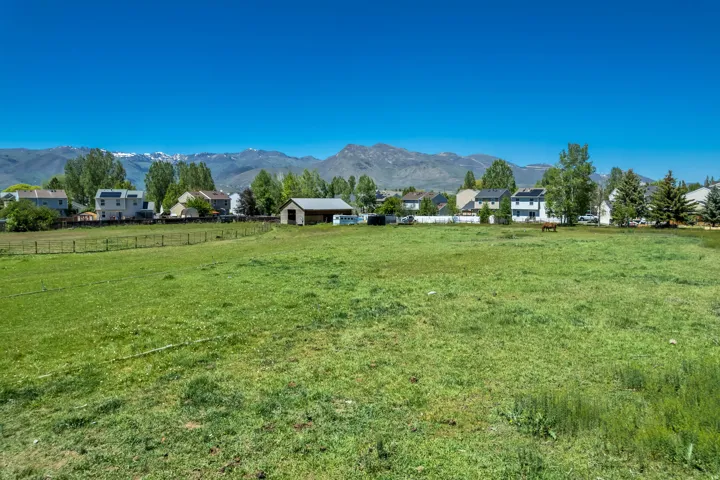 Expansive green pasture with a rustic barn structure