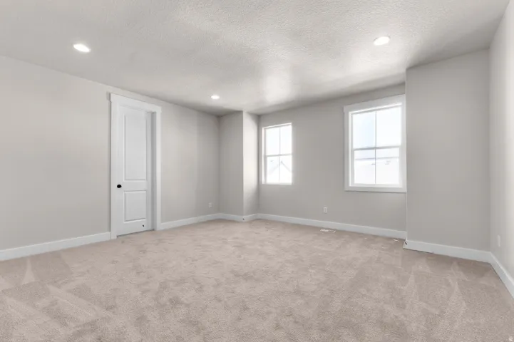 Neutral wall color, recessed lighting, white trim, paneled interior door, and carpet flooring