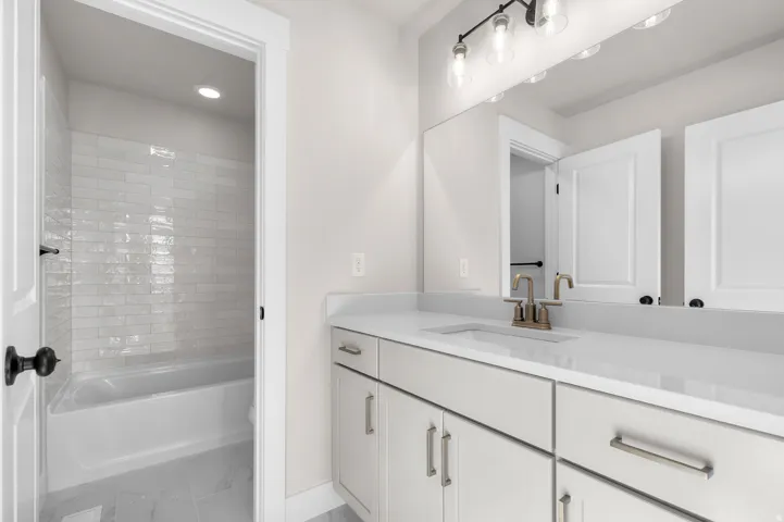 Vanity with an integrated sink, polished countertop, and brushed brass-finish faucet