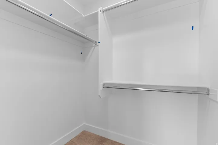 White built-in shelving system with chrome hanging rods