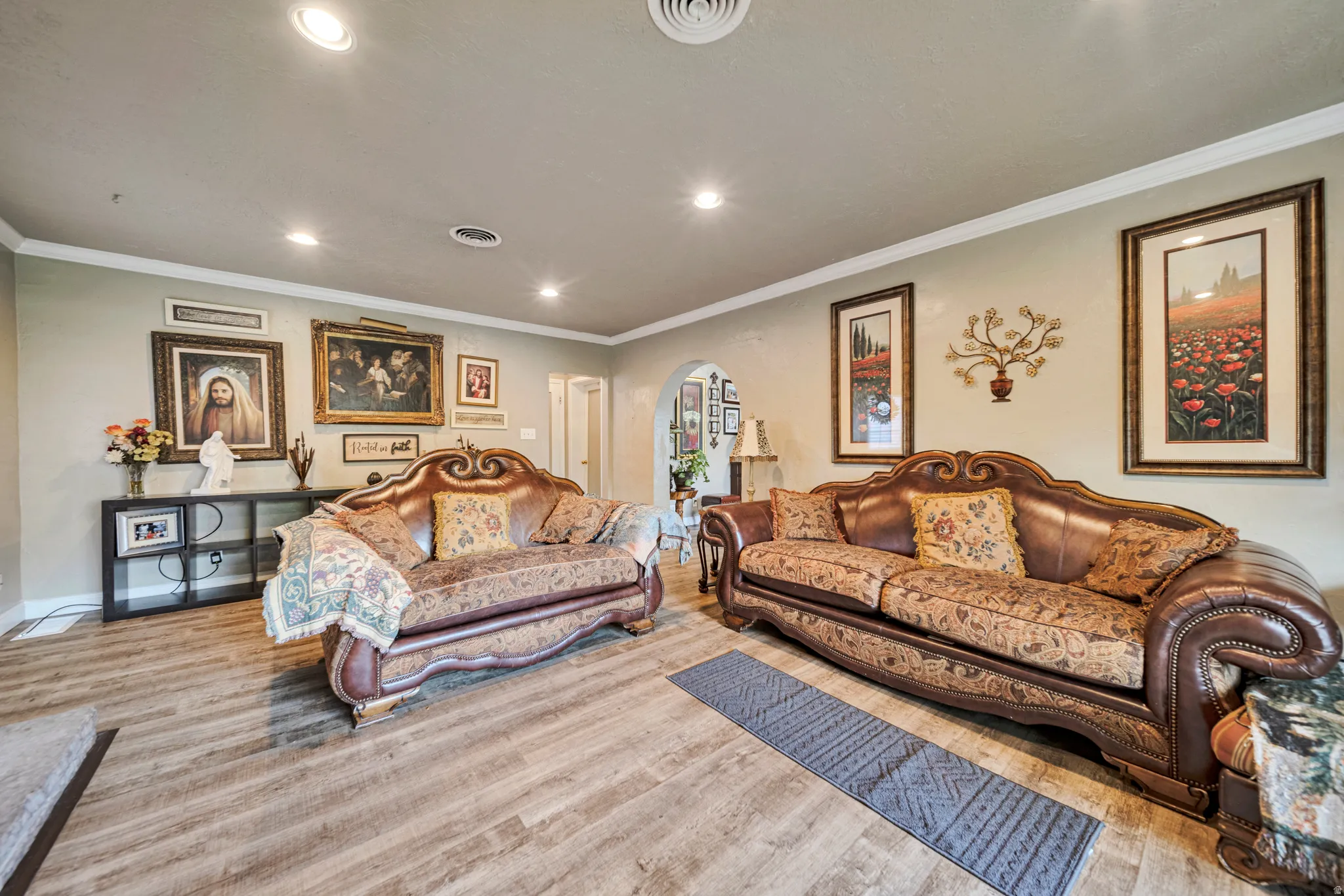 Spacious interior featuring wood-finish flooring, recessed ceiling lighting, crown molding, and a neutral wall palette