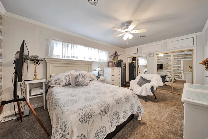 Bedroom featuring carpeted flooring and a built-in closet with mirrored sliding doors