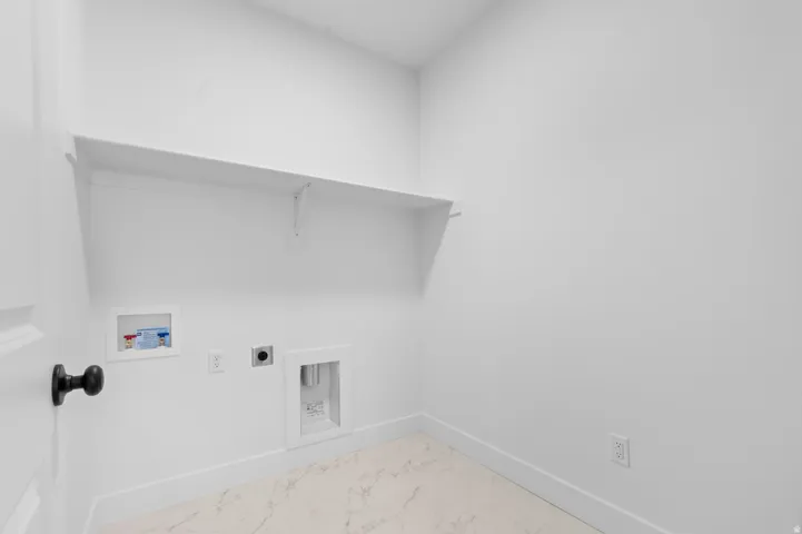 Dedicated laundry area featuring a built-in shelf, appliance hookups, and light-toned tile flooring