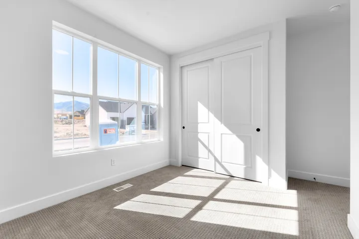 Recessed lighting, white walls, and light-toned carpet flooring