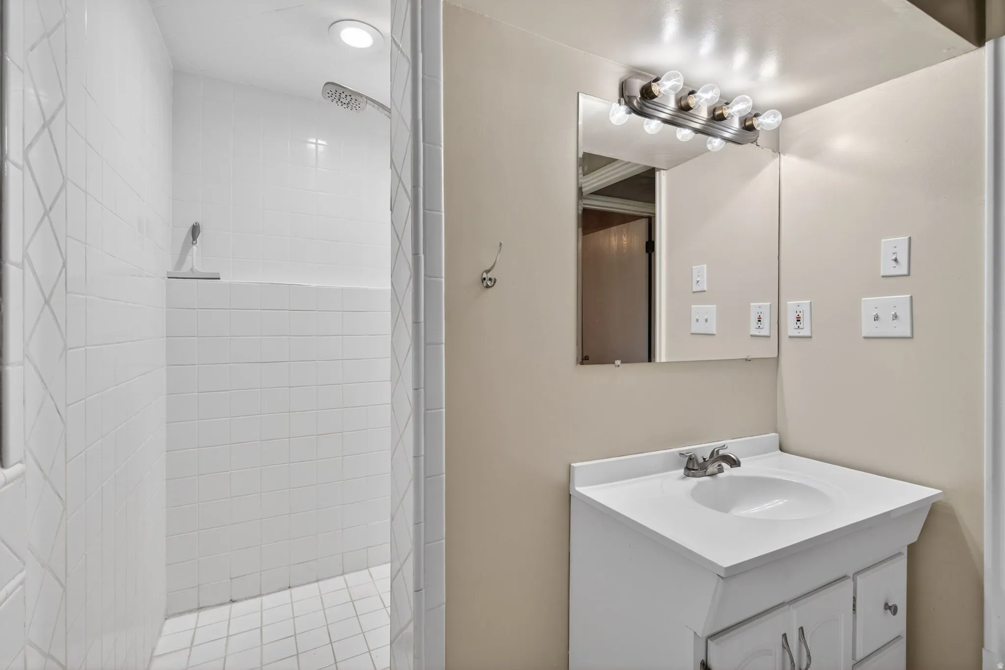 White tiled walk-in shower with a built-in bench