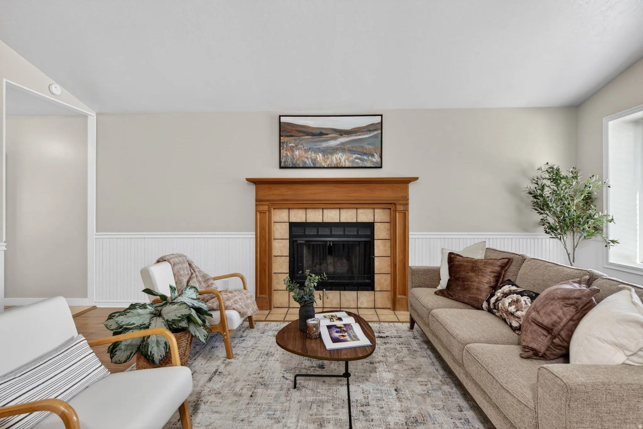 Living area featuring a fireplace with a wood mantle and tiled surround