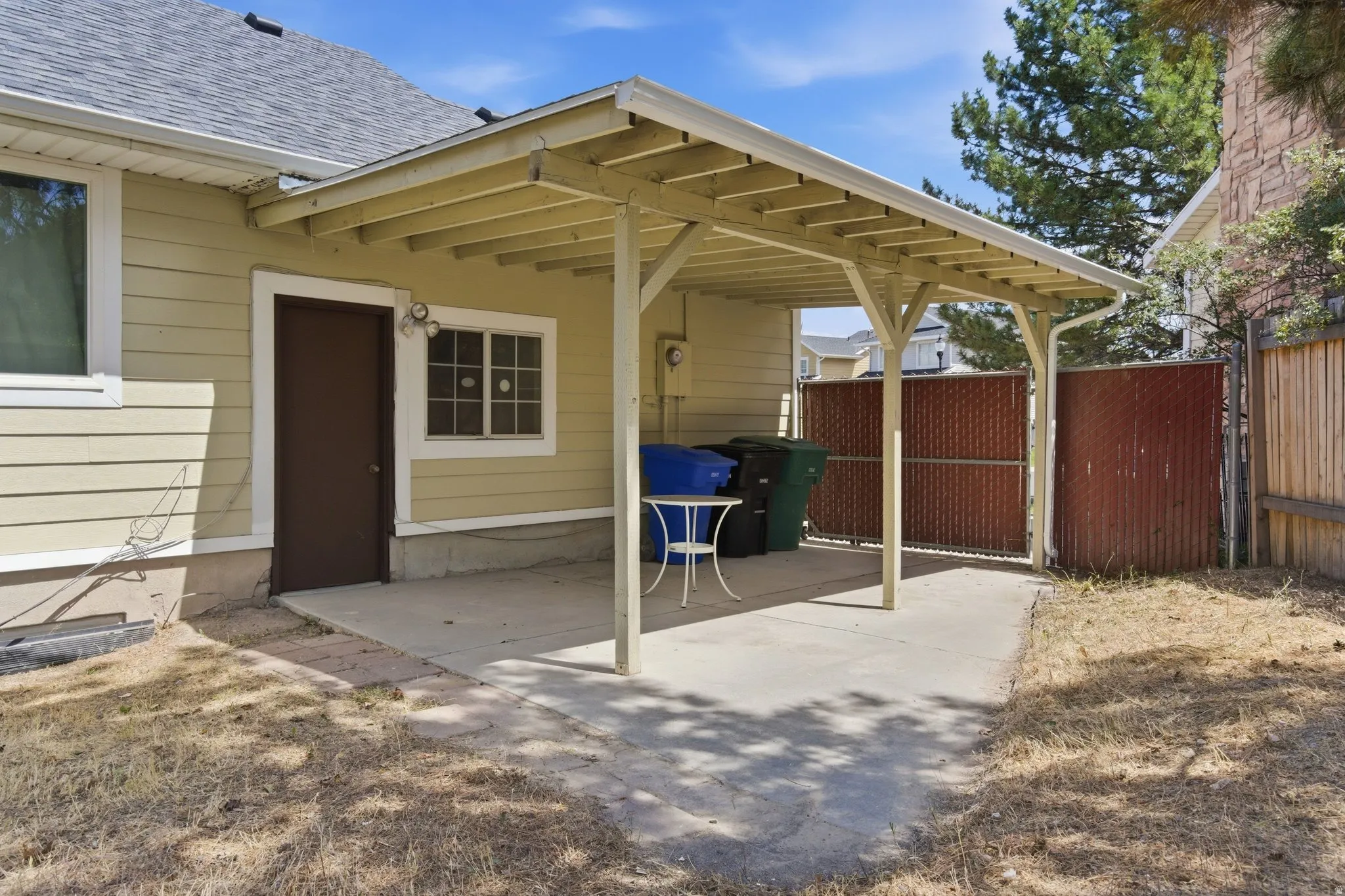 Covered carport provides sheltered parking or outdoor living space