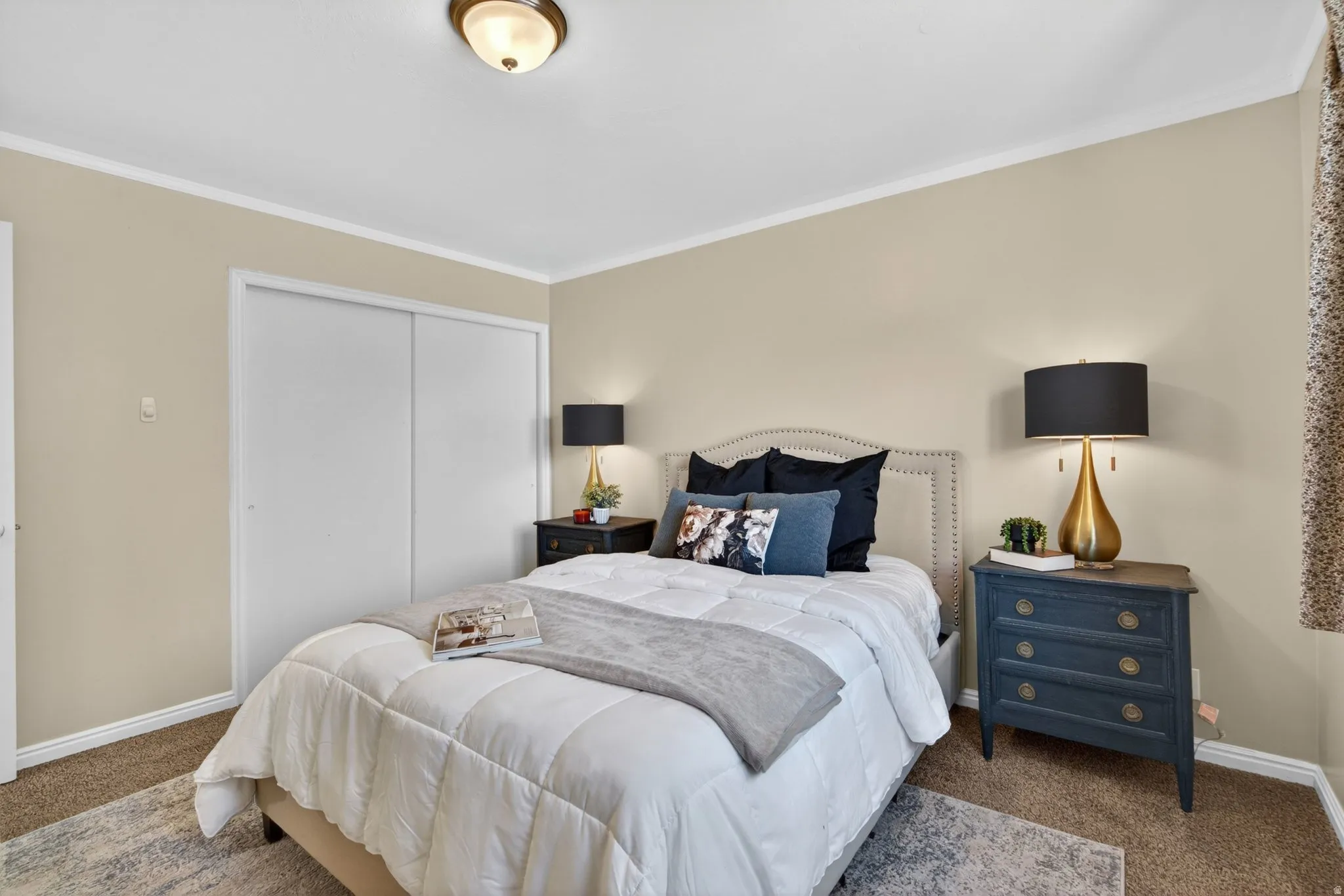 Carpeted bedroom with neutral wall tones and white crown molding