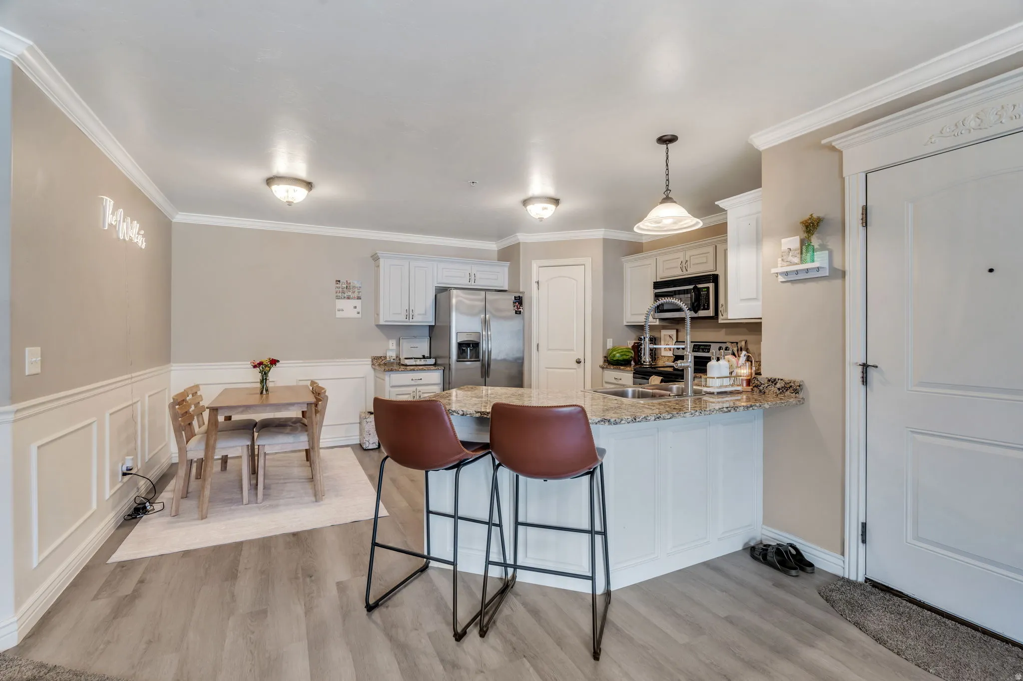 Open-concept kitchen and dining area featuring light wood-finish flooring