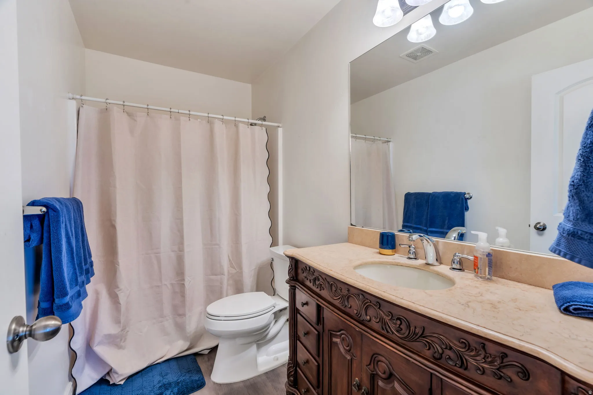 Bathroom vanity featuring an integrated oval sink, polished chrome faucet, and a light-toned countertop