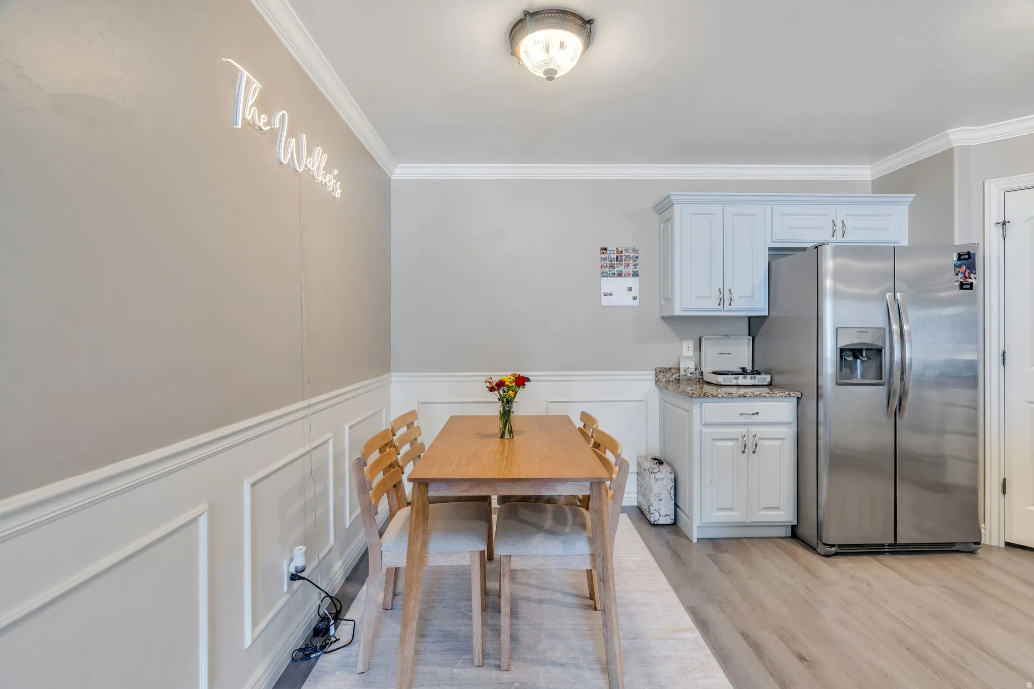 Dining area featuring wainscoting, crown molding, and recessed lighting