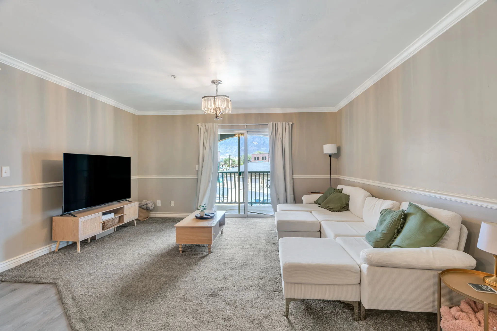 Living space featuring crown molding and two-tone wall treatment