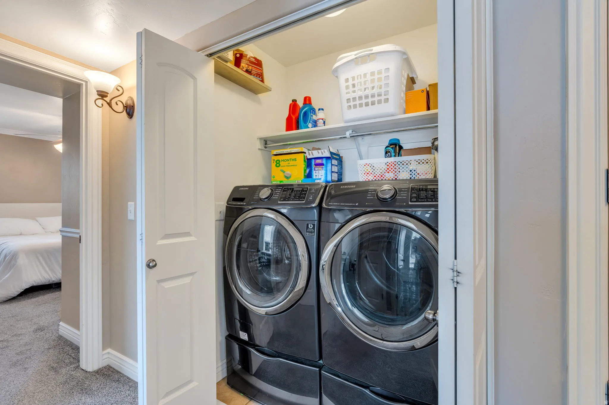 Dedicated laundry area with built-in shelving, two appliances, and overhead storage options