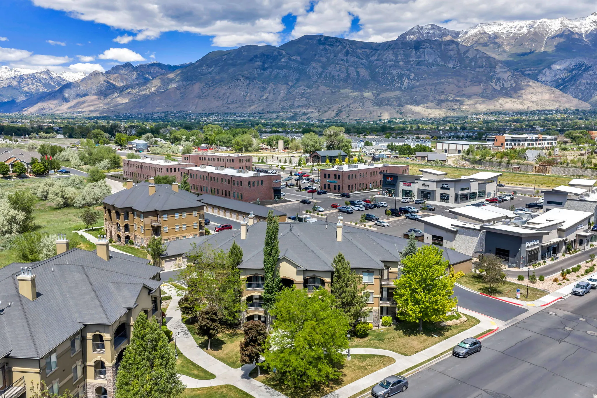 Aerial perspective showcasing modern multi-story residential buildings with dark gray roofs and light-colored siding