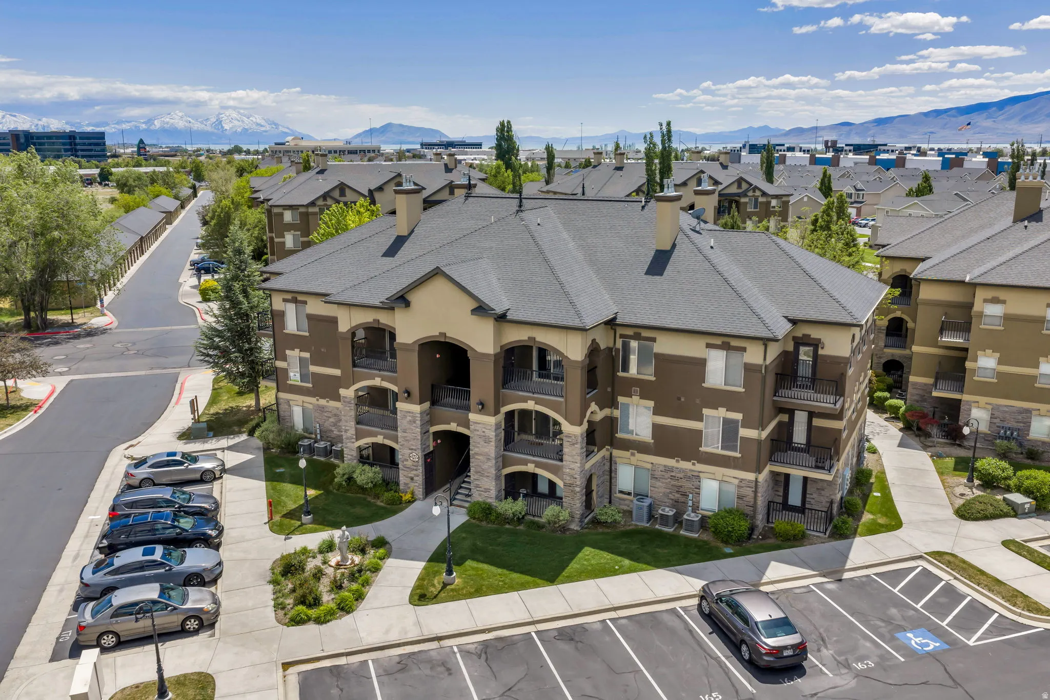 Multi-story apartment building featuring a neutral color palette, stone accents, and private balconies