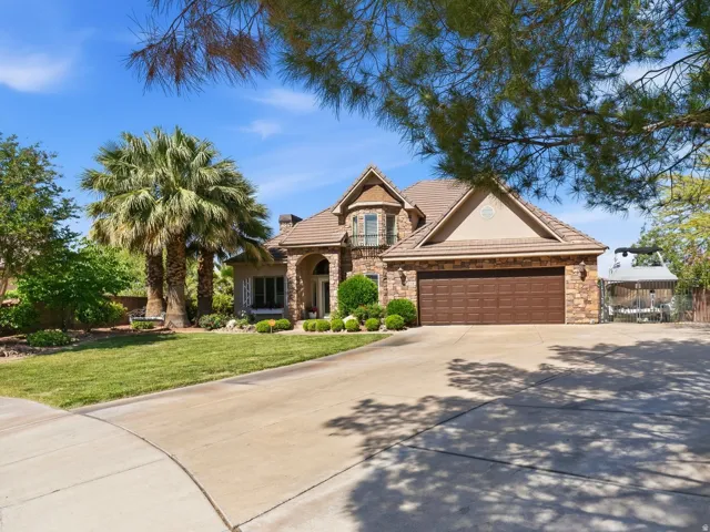 Stone and stucco exterior with an arched entry, a prominent bay window, and a two-car garage