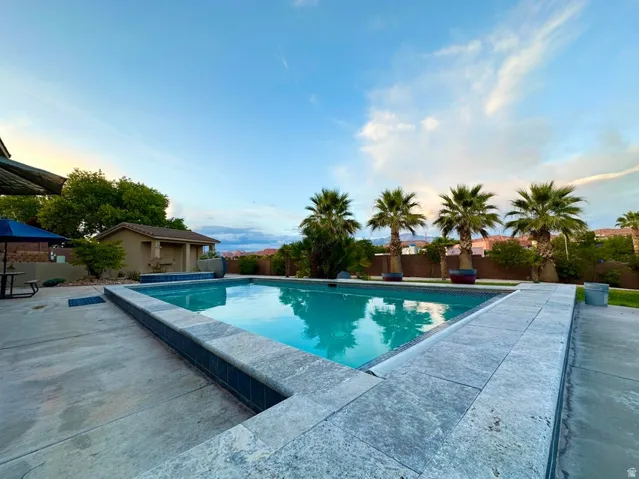 Rectangular swimming pool featuring a tiled waterline and coping, surrounded by concrete decking