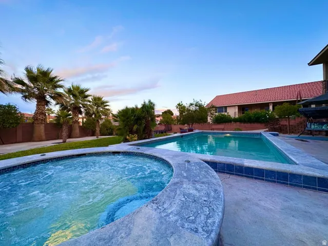 Outdoor oasis featuring a rectangular swimming pool and a circular spa
