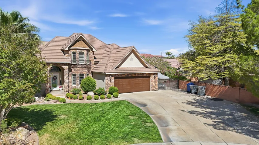 Stately residence featuring a stone and stucco exterior, arched entry, and a tile roof