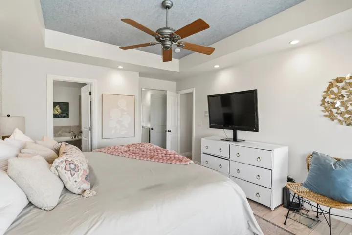 Tray ceiling featuring a wood-finish ceiling fan and recessed lighting