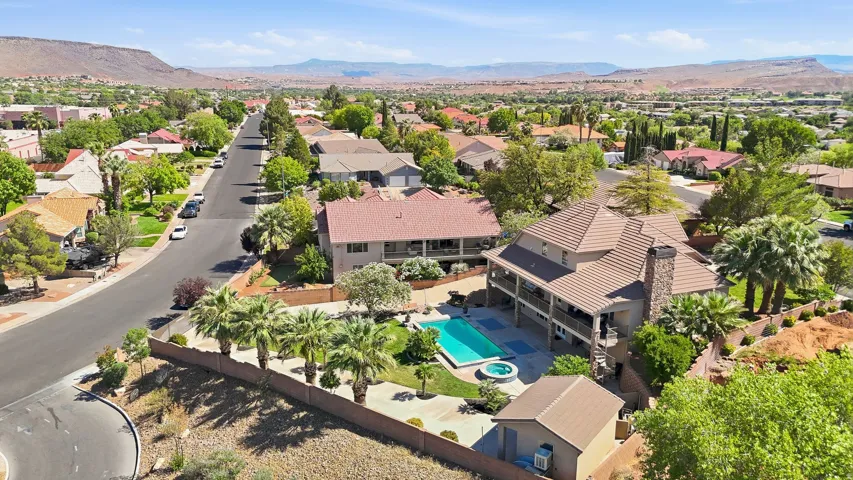 Elevated property featuring a tiled roof, multi-level patio, an outdoor pool, and an integrated spa