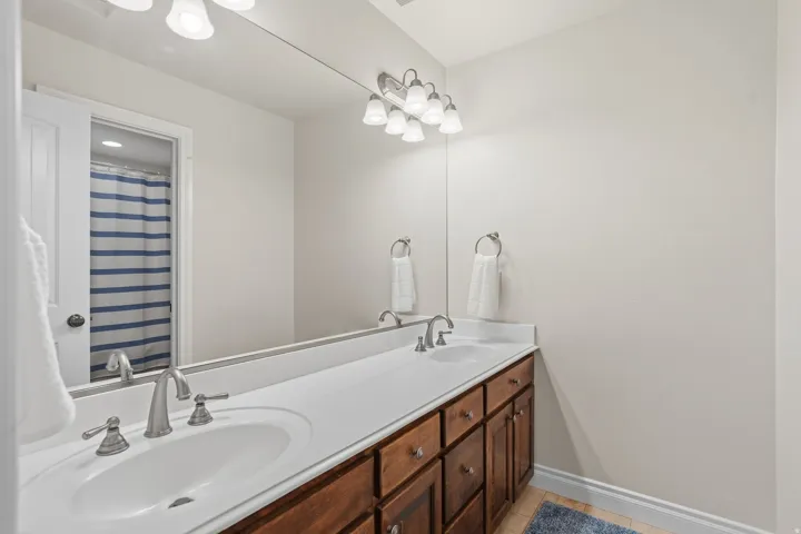 Bathroom featuring a dual-sink vanity with white countertops, undermount sinks, and brushed nickel faucets