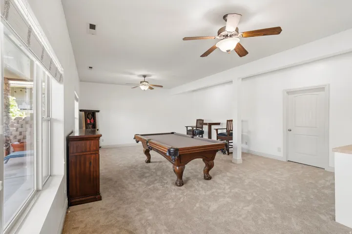 Spacious recreation room featuring neutral carpeting and white walls