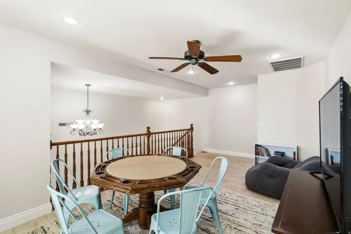 Spacious bonus room featuring light wood-finish flooring and a wood banister