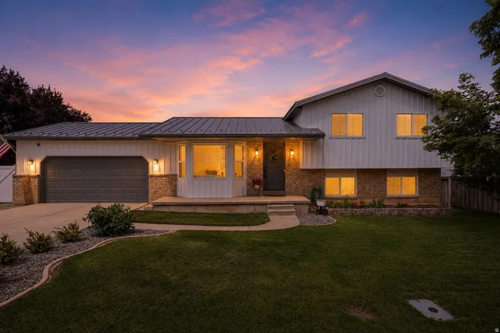 Exterior featuring a metal roof, two-tone siding, and a stone facade