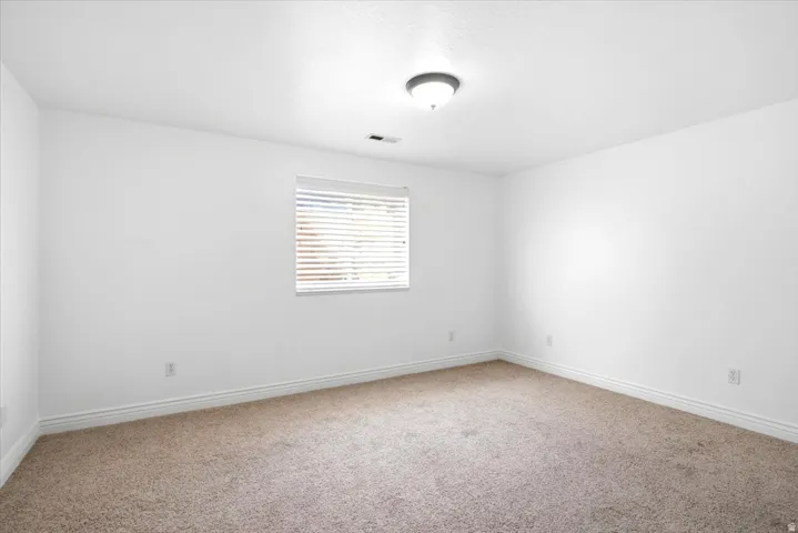 Neutral-toned carpeting paired with white baseboards and walls